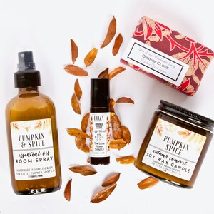 May include: A set of fall-themed home fragrance products featuring a pumpkin spice room spray, a soy wax candle, and a roll-on essential oil. The products are all labeled with the text "Pumpkin & Spice" and "The Little Flower Soap Co."