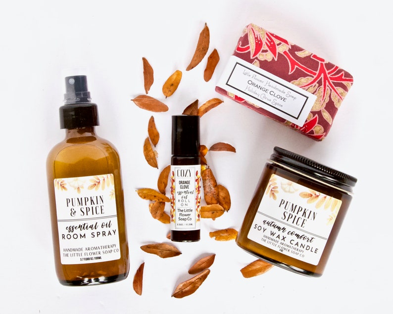 May include: A set of fall-themed home fragrance products featuring a pumpkin spice room spray, a soy wax candle, and a roll-on essential oil. The products are all labeled with the text "Pumpkin & Spice" and "The Little Flower Soap Co."