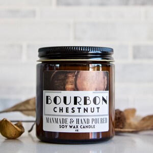 Puede incluir: Una vela de vidrio marr&oacute;n con tapa negra y una etiqueta blanca que dice "Bourbon Chestnut" y "Handmade & Hand Poured Soy Wax Candle 4 oz."