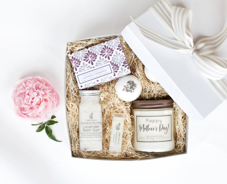 Op de afbeelding: Een witte cadeaudoos gevuld met lavendelbadzout, een lavendelzeep, een badbom en een sojawas-kaars met de tekst "Happy Mother's Day!" op het etiket.
