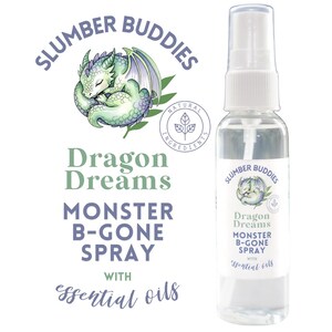 May include: A clear spray bottle with a white cap, labeled "Slumber Buddies Dragon Dreams Monster B-Gone Spray with essential oils." The label features a sleeping dragon illustration and the words "Natural Ingredients."