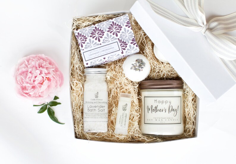 Op de afbeelding: Een witte cadeaudoos gevuld met lavendelbadzout, een lavendelbadbom, een lavendellipbalsem, een lavendelzeep en een sojawas-kaars met de tekst "Happy Mother's Day!"
