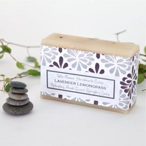 May include: A bar of lavender lemongrass soap with a white label that reads "Little Flower Handmade Soap Lavender Lemongrass Relaxing, Fresh Scent, Everyday Soap" and a gray and purple floral pattern.