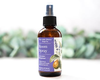 May include: An amber glass spray bottle with a black nozzle and a white label. The label features the text The Little Flower Soap Co, Room Spray, Lavender Bergamot, and Net Wt. 3.7 FL OZ (109 ml) with botanical illustrations of lavender and bergamot.