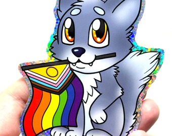 May include: A sticker featuring a cartoon wolf with gray fur, large orange eyes, and a rainbow flag in its mouth. The sticker has a holographic border and a white background.