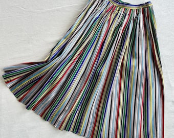 May include: A pleated skirt with a colorful striped pattern in shades of red, blue, green, yellow, and white.