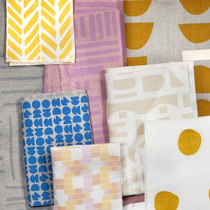 May include: Assortment of fabric swatches with different geometric patterns and colors, including yellow, blue, pink, and white.