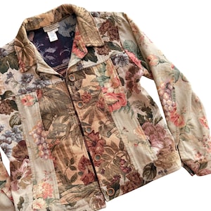 May include: A floral tapestry jacket with a button-up front. The jacket features a variety of flowers in shades of pink, brown, and green. The jacket has a collared neckline and long sleeves.