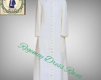 Könnte beinhalten: Ein langer, weißer Geistlichenrock mit Stehkragen und Knopfleiste vorne. Der Rock wird auf einer Schaufensterpuppe präsentiert und hat lange Ärmel. Der Text "Regency Dress Rules" ist in grüner Schreibschrift geschrieben. Ein Logo befindet sich in der oberen linken Ecke.