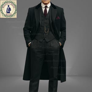 May include: A dark gray three-piece suit with a long overcoat. The suit includes a vest, trousers, and a jacket with a velvet collar. A burgundy pocket square and tie add color. The image includes the text "REGENCY DRESS RULES".