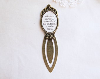 May include: A bronze bookmark with an oval-shaped glass charm featuring the quote "Whatever our souls are made of, his and mine are the same."
