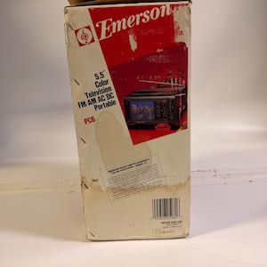 K&ouml;nnte beinhalten: Vintage Emerson-Box mit dem Markennamen in Rot. Die Box enth&auml;lt den Text "5,5" Color Television FM/AM AC/DC Portable PC6." Ein Bild eines kleinen Fernsehers ist ebenfalls sichtbar.