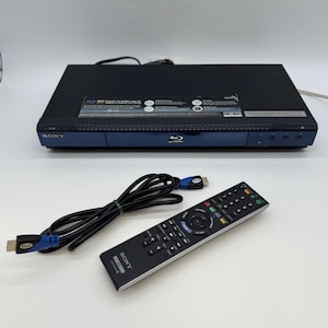 May include: A black Sony Blu-ray player with a matching remote control and an HDMI cable. The player has a blue accent on the front and the remote has numerous buttons. The HDMI cable is black with blue connectors.