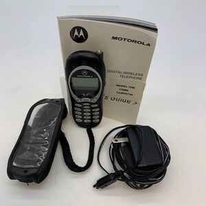 May include: A black Motorola 120c digital wireless telephone with a screen and keypad. Included are a black carrying case, charger, and a user guide. The Motorola logo is visible on the phone and the guide.