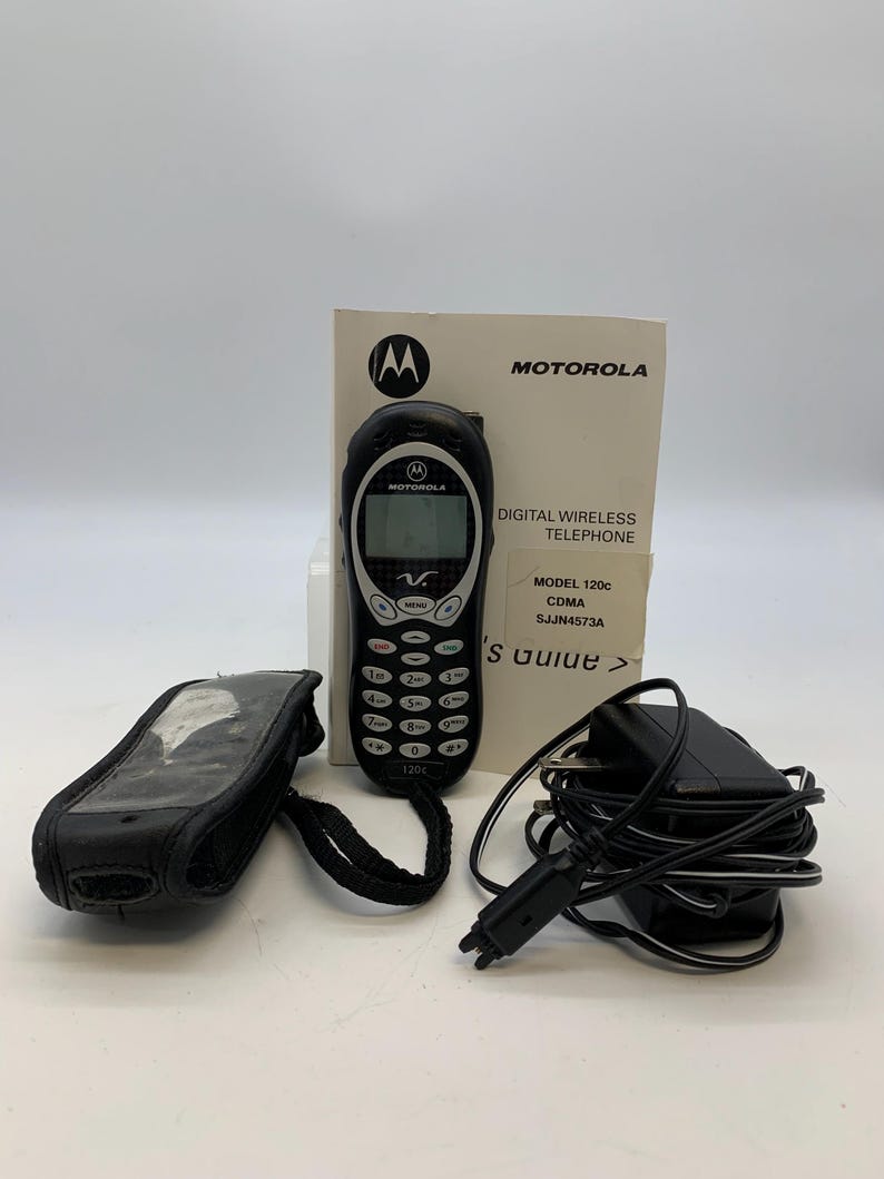 May include: A black Motorola 120c digital wireless telephone with a keypad, screen, and antenna. Included are a black carrying case, charger, and user guide. The phone has the Motorola logo and model information printed on it.