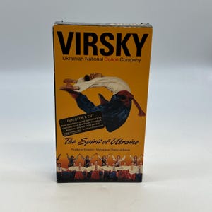 May include: A VHS tape box for "VIRSKY Ukrainian National Dance Company." The box is primarily orange with the title in large black letters. It features an image of a dancer in mid-air and the text "The Spirit of Ukraine."