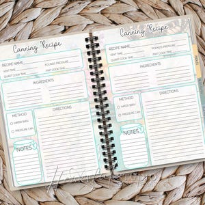 K&ouml;nnte beinhalten: Offenes Spiralnotizbuch mit dem Titel "Canning Recipe". Die Seiten enthalten Ausf&uuml;llfelder f&uuml;r Rezeptnamen, Zutaten, Anweisungen und Notizen. Das Notizbuch hat ein t&uuml;rkis- und florales Design mit Registerkarten f&uuml;r verschiedene Arten von Lebensmitteln.