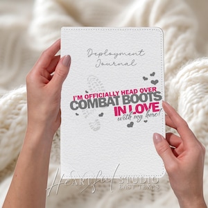 Może przedstawiać: Biały dziennik Deployment z tekstem "I'M OFFICIALLY HEAD OVER COMBAT BOOTS IN LOVE with my hero!" w kolorze różowym i szarym. Dziennik ma kropkowaną obwódkę i małe grafiki serca.