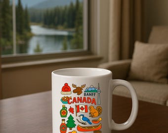May include: White ceramic mug featuring colourful illustrations of Canadian symbols, such as a maple leaf, moose, and the CN Tower. The mug has the word "BANFF" and "CANADA" printed on it. The mug is on a wooden table with a window and a Canadian flag in the background.