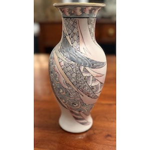 May include: A ceramic vase with a flared rim and a tapered base, featuring a decorative surface pattern of stylized feathers in shades of grey, soft pink, and white, with intricate cross-hatching and circular details throughout the design.