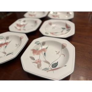 May include: A set of white octagonal soup bowls featuring a delicate floral pattern with soft pink petals and muted green leaves. Each bowl has a subtle gray rim detail, providing a clean and structured look for serving various liquid-based dishes.