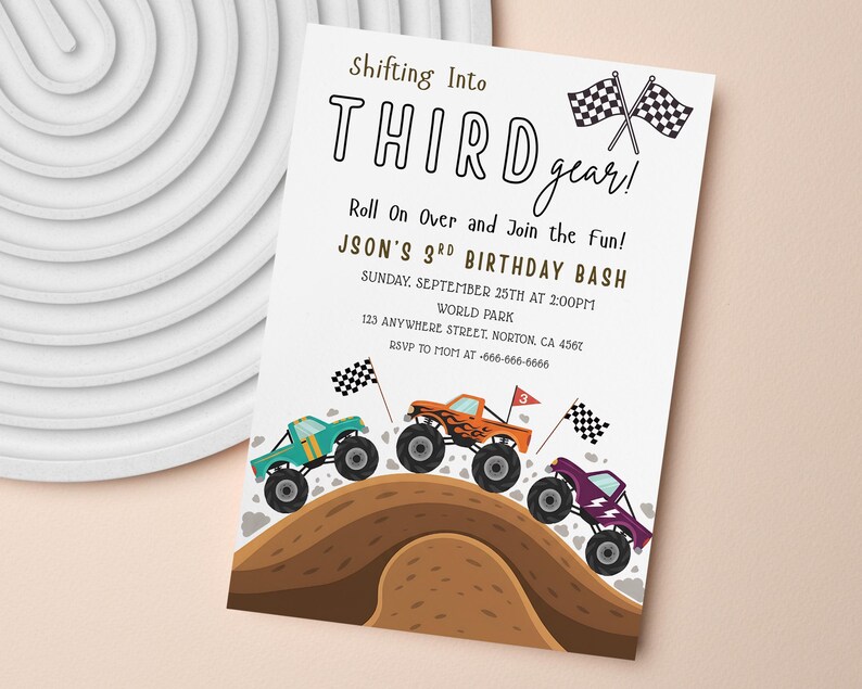 May include: A white invitation card with the text "Shifting Into THIRD gear!" and "JASON'S 3RD BIRTHDAY BASH". The card features illustrations of monster trucks in teal, orange, and purple, racing over a brown hill, with checkered flags.