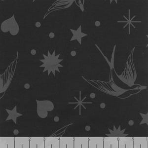 May include: Dark gray fabric with a repeating pattern of stylized birds, stars, hearts, and dots. The design elements are in a lighter shade of gray, creating a subtle contrast. The overall aesthetic is vintage and whimsical.