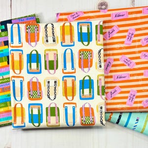 May include: Four folded fabric pieces featuring distinct patterns: a stack of colorful books, a grid of small backpacks in various colors, orange horizontal stripes with pink rectangular labels, and a light blue background with diagonal pencils.