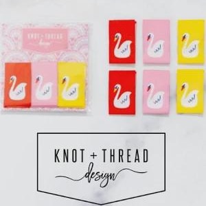 May include: A set of six rectangular fabric labels featuring a white swan graphic on red, pink, and yellow backgrounds. Three labels are packaged in a clear plastic sleeve with a header card labeled KNOT + THREAD design, and three are loose.