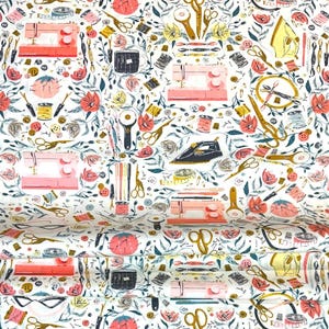 May include: White fabric with a repeating pattern of sewing machines, scissors, flowers, and other sewing notions in shades of pink, gold, black, and teal. The design includes spools of thread, buttons, and rotary cutters.