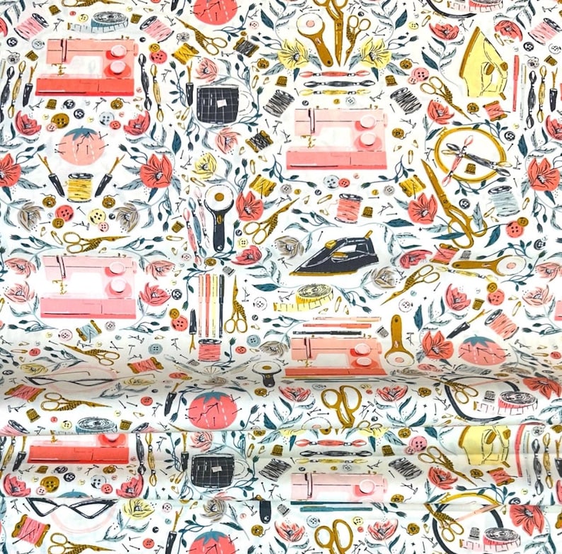 May include: White fabric with a repeating pattern of sewing machines, scissors, flowers, and other sewing notions in shades of pink, gold, black, and teal. The design includes spools of thread, buttons, and rotary cutters.