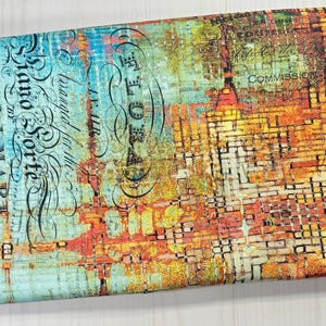 May include: Rolled fabric with an abstract design in shades of blue, orange, yellow, and brown. The fabric features text and a distressed, vintage aesthetic. The words "Piano Sorte" and "Abandoned" are visible.