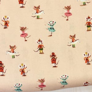 May include: Cream-colored fabric with a repeating pattern of cartoon mice in various outfits. Some mice wear tutus, others are dressed as soldiers or royalty. The fabric has the text "Heather Ross Studio Edit" printed on the selvage.