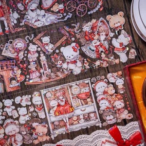 May include: Decorative stickers with a vintage theme, featuring teddy bears, girls, and other romantic elements. The stickers are in various sizes and shapes, with a colour palette of red, white, and brown.