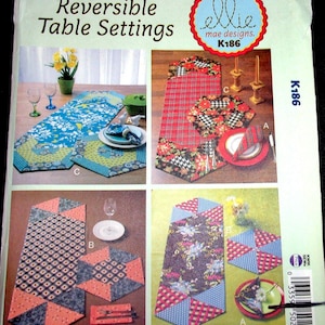 May include: A sewing pattern for reversible table settings. The pattern includes four different designs: a red and black plaid, a blue and green floral, a pink and gray geometric, and a blue and white floral. The pattern is from Ellie Mae Designs and is numbered K186.