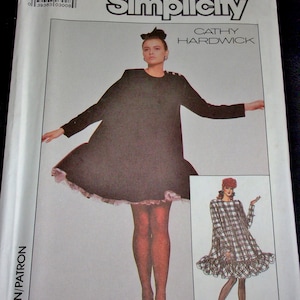 May include: Simplicity sewing pattern 8349 featuring a woman in a dark dress with a flared hem and a contrasting trim. The pattern includes a smaller image of a plaid dress. The pattern size is OO (12-18).