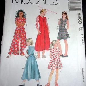 May include: McCall's sewing pattern featuring illustrations of girls' dresses and jumpsuits. The designs include a red floral jumpsuit, a red button-down dress, a plaid dress, a denim jumper, and a floral dress. The pattern size is CF (4,5,6).
