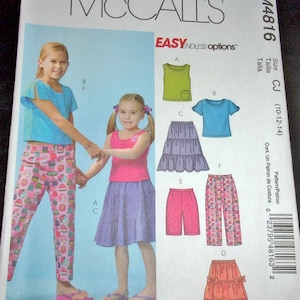 May include: McCall's sewing pattern M4816 featuring girls' clothing designs. The pattern includes options for tops, skirts, and pants. The image shows illustrations of the finished garments, including a tank top, t-shirt, shorts, and tiered skirt.