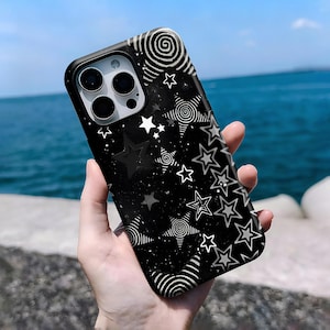 May include: Black phone case with a star pattern. The case features a repeating design of white and gray stars, swirls, and dots against a black background. The phone case has a glossy finish and a camera cutout.
