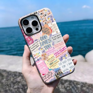 Puede incluir: Una funda de teléfono con un diseño de collage con el texto "GOD LOVES YOU" y otras frases inspiradoras. La funda tiene una mezcla de colores pastel y acentos florales, con un acabado brillante.