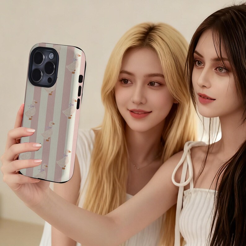 May include: A smartphone case with a pink and white striped pattern and a repeating illustration of a goose. The case is held by a person. The case has a black border and a camera cutout.