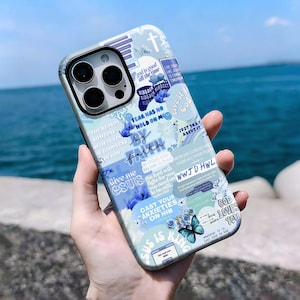 Może przedstawiać: Jasnoniebieskie etui na telefon z kolażem inspirujących tekstów i kwiatowych wzorów. Etui zawiera frazy takie jak "Bóg jest dobry" i "Przez wiarę" w białych i niebieskich czcionkach. Obecna jest również grafika motyla.
