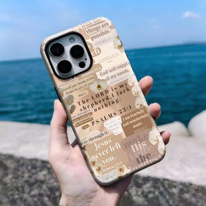 May include: A phone case with a beige and brown collage design featuring floral accents and religious text. The case includes phrases like "With God things are possible" and "The Lord is my shepherd. I lack nothing."
