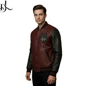 May include: A burgundy and black leather varsity jacket with a wolf emblem on the chest. The jacket features black sleeves, a black collar, and a striped hem. The jacket has a button-up front.