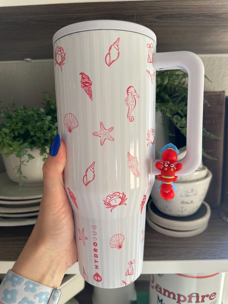 May include: White Hydro Jug with red seashell, starfish, and ice cream cone illustrations. The jug has a white handle and a red lobster charm. The text "HYDRO JUG" is printed on the side.