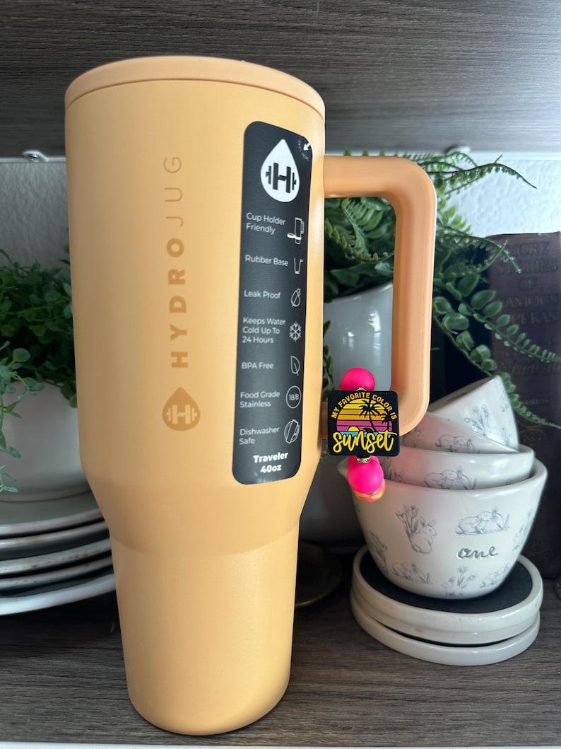 以下が含まれることがあります： 黒いハンドルが付いた白いセラミックマグカップで、太字の黒いフォントで「But First, Coffee」と書かれています。 マグカップはニュートラルな背景に置かれ、シンプルなデザインを際立たせています。