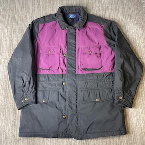 May include: A two-tone jacket with a purple upper chest and pocket area, and a dark gray lower section. The jacket has a collared neckline, four front pockets, and gold-colored button closures. The brand name "Zory" is visible on the label.