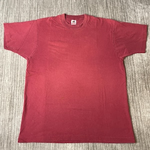 Könnte beinhalten: Ein einfarbiges, dunkelrotes T-Shirt mit kurzen Ärmeln und Rundhalsausschnitt. Das Kleidungsstück verfügt über ein eingenähtes Etikett der Marke Fruit of the Loom im Kragenbereich. Der Stoff weist eine gleichmäßige Textur auf der Vorderseite auf.
