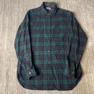 May include: A long-sleeve button-down shirt featuring a dark green and black plaid pattern. The shirt has a pointed collar, a single chest pocket on the left side, buttoned cuffs, and a central button placket. A Pendleton brand label is visible.