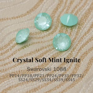 May include: Four pale green Swarovski crystals with the text "Crystal Soft Mint Ignite" and "Swarovski 1088". The crystals are in different shapes, with a faceted design. Measurements are also included.